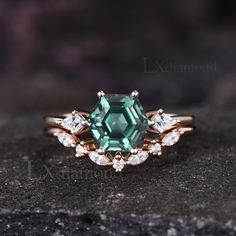 an emerald colored stone surrounded by white diamonds