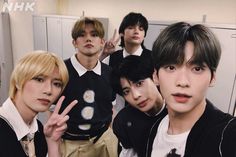 the group of young men are posing for a photo in front of lockers with their fingers up