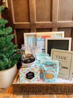 an assortment of items sitting on top of a wooden box next to a potted tree