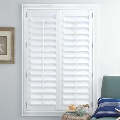 a room with blue walls and white shutters