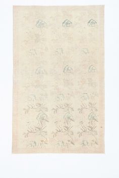 an antique rug with birds and flowers on it, in cream color against a white background