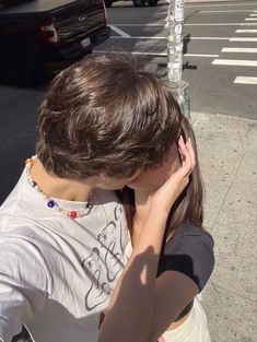 a person standing on the sidewalk with their head in his hands