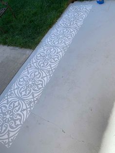 the cement is painted with white stencils to create a decorative pattern on it