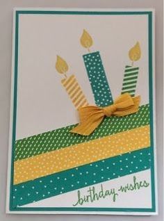 a birthday card with two candles and a bow on the top, sitting on a table