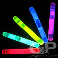 glowsticks in different colors are arranged on a black background