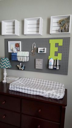 a baby's crib in the corner of a room with pictures on the wall