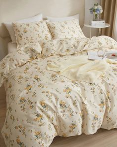 a white bed with yellow and blue flowers on it