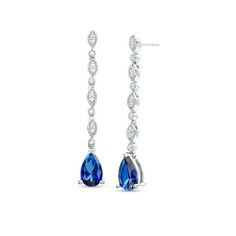 Bursting with colour, these fabulous vintage-inspired drop earrings are anything but ordinary. Fashioned in sterling silver, each enticing drop features an 8.0 x 5.0mm pear-shaped lab-created bright blue sapphire dangle. Along the linear drop, lab-created white sapphires in milgrain-lined bezel settings alternate with paired created sapphires in marquise-shaped frames lined with intricate milgrain detailing. Polished to a bright shine, these post earrings secure comfortably with friction backs. Sapphire Earrings Drop, Sapphire Drop Earrings, Wedding Earrings Drop, Peoples Jewellers, Coin Jewelry, Elizabeth Taylor, Sapphire Earrings, Sapphire Stone, Blue Earrings