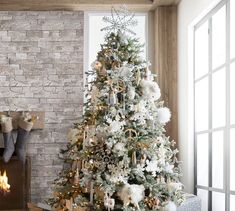 a decorated christmas tree in front of a fireplace