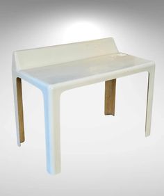 a white plastic table with wooden legs