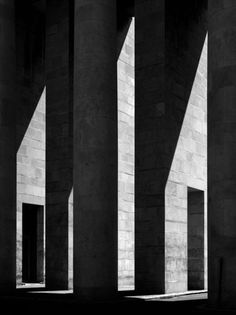 black and white photograph of shadows on the side of an architectural building with concrete columns