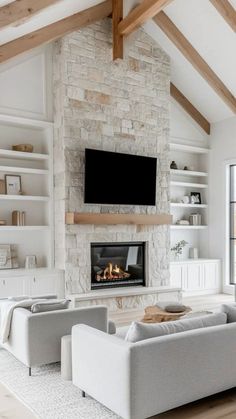 a living room filled with furniture and a flat screen tv mounted on the wall above a fireplace