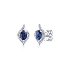 Add a dramatic splash of color and sparkle to your ensemble with these sapphire and diamond earrings. Brilliant .24ct pave diamonds set in 14 white gold form a modified pear shaped halo around regal oval cut sapphires. 14k White Gold Diamond Halo Oval Cut Sapphire Stud Earrings | EG13116W44SA Engagement Rings | Fashion Jewelry | Gabriel NY #diamondearrings #sapphireearrings #uniqueearrings Fine Jewelry Sapphire Earrings With Halo Design, Oval Sapphire Earrings, Sapphire Halo Earrings Fine Jewelry, Sapphire Oval Diamond Earrings, Blue Sapphire Oval Diamond Earrings, Luxury Sapphire Earrings With Halo Setting, Sapphire Earring, Light Blue Sapphire, Sapphire Stud Earrings