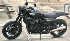 a black motorcycle parked in front of a bench