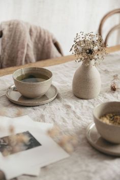 a table topped with two cups and saucers