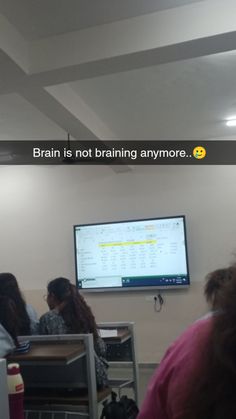 some people are sitting at desks in front of a large screen with the words brain is not training anymore