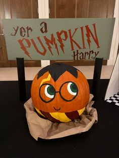 a pumpkin sitting on top of a table next to a sign that says, yer a pumpkin harry