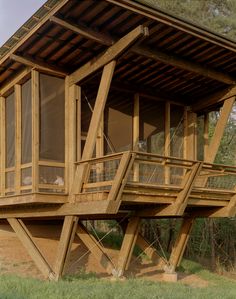 a wooden structure sitting on top of a lush green field