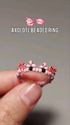 someone is holding their tiny beaded ring in their hand with the words axoloti beaded ring on it