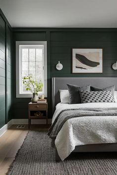 a bedroom with dark green walls and white bedding in the center, along with a gray rug on the floor