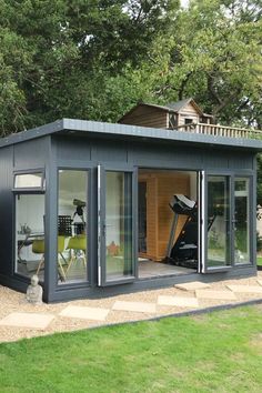 a small shed with sliding glass doors on the front and side door open to let in lots of natural light