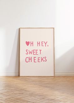 a pink poster with the words oh hey, sweet cheeks on it in front of a white wall