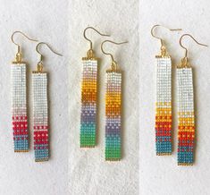 three pairs of beaded earrings with different colors and shapes on white fabric, side by side