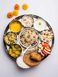 a plate full of different types of food on top of a white table with orange and yellow flowers