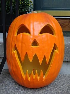 a carved pumpkin sitting on the ground with its mouth open