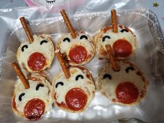 small pizzas with pepperoni, cheese and sausage sticks sticking out of them to look like faces