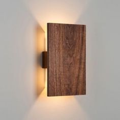 a wooden light fixture mounted on the side of a wall