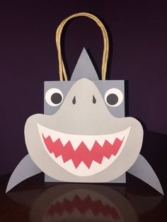 a paper bag with a shark's mouth on it and two handles hanging from the front