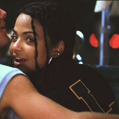 a man with dreadlocks kissing a woman on the cheek