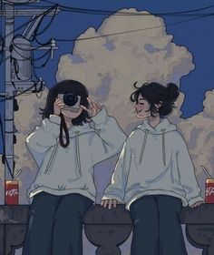 two people are sitting on a ledge with their backs turned to look at something in the distance