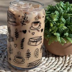 a drink sitting on top of a wicker table next to a potted plant