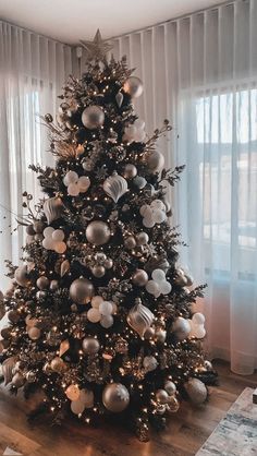 a decorated christmas tree with white and silver ornaments