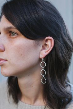 These silver dangle earrings are reminiscent of juicy pears, ripe on the branch, and heavy with the promise of sweet nectar.  Decidedly bohemian, these drop earrings are lovingly crafted with only the highest quality sterling silver wire formed and hammered for just the right sparkle. Long silver earrings are a lovely addition to any outfit and would be especially dramatic paired against solid, darker colors.  Each pair of these hammered silver earrings measures approximately 3 inches long by ½ Nickel-free Dangle Teardrop Earrings, Nickel-free Teardrop Dangle Earrings, Everyday Nickel-free Teardrop Dangle Earrings, Nickel-free Dangle Drop Earrings, Everyday Dangle Drop Earrings With Matching Set, Metal Teardrop Linear Earring, Everyday Pear-shaped Silver Jewelry, Everyday Hypoallergenic Teardrop Linear Earrings, Hypoallergenic Metal Dangle Teardrop Earrings