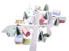 paper houses and trees are arranged in the shape of a cross on a white background