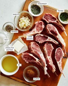 raw meat on a wooden cutting board with spices and seasonings around the steaks