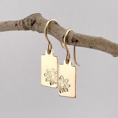 "Bold Flower Botanical Hand Stamped Rectangle Drop Earrings in 14k gold filled  * Earrings are TINY in size... overall length is just about 1\" with ear wires, and around 1.2\" with lever backs. Perfect for all day wear! * Tags are 14k gold filled and are 14x6mm in size * Earrings are packaged in a gift box and placed in an organza gift bag ready for gift giving * Gift messages and wrapping are also available (mark order as a gift and you will see message and wrapping options) * Hand stamped by Everyday Dangle Earrings With Flower Charm, Delicate Flower Charm Earrings For Everyday, Everyday Drop Earrings With Flower Charm, Minimalist Everyday Earrings With Flower Charm, Everyday Single Dangle Flower Earring, Everyday Minimalist Earrings With Flower Charm, Everyday Flower Charm Drop Earrings, Minimalist Dangle Earrings With Flower Charm, Everyday Flower Drop Earrings