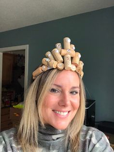 a woman wearing a hair piece made out of wine corks and other things on her head