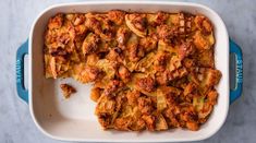 a casserole dish with meat and onions in it on a marble counter top