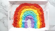 a rainbow cake on a white platter