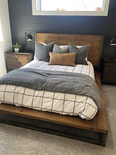 a bed with two nightstands and a window in the background, along with other furniture