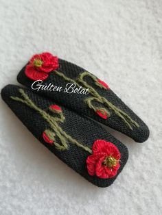 two black and red flowered hair clips on a white surface with the words garden thread written across them