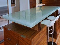 a kitchen island with three stools in front of it