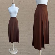 vintage brown wool skirt. high waist. inverted pleats at front and back of skirt. hip pockets. belt loops. side button closure + an interior hook & eye. falls mid calf/ midi length. skirt is lined.  🌴 A beautiful designer skirt that is reminiscent of and certainly inspired by the Edwardian era.  Circa 1980s  Perry Ellis Neiman Marcus 100% Wool Brown Tagged Size 6 Excellent. No notable flaws. Dry Cleaned. ✂----M e a s u r e m e n t s: all in inches. Waist: 26 Hips: up to 38 Length: 34 Hem Allowa Brown Workwear Midi Skirt, Brown Midi Length Workwear Bottoms, Fitted Midi Skirt In Brown, Brown Midi Skirt For Work, Brown Midi Length Bottoms For Work, Retro Pleated Brown Skirt, Brown Pleated Midi Skirt For Work, Elegant Brown Full Skirt Bottoms, Vintage Knee-length Brown Skirt