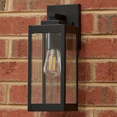 an outdoor light on the side of a brick wall