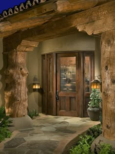 an image of a front door and entry way with the caption'i love several elements of this entryway - the tree trunk pillars, the path, the path and