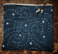 a blue pouch with white stars and beads on the inside is sitting on a wooden surface